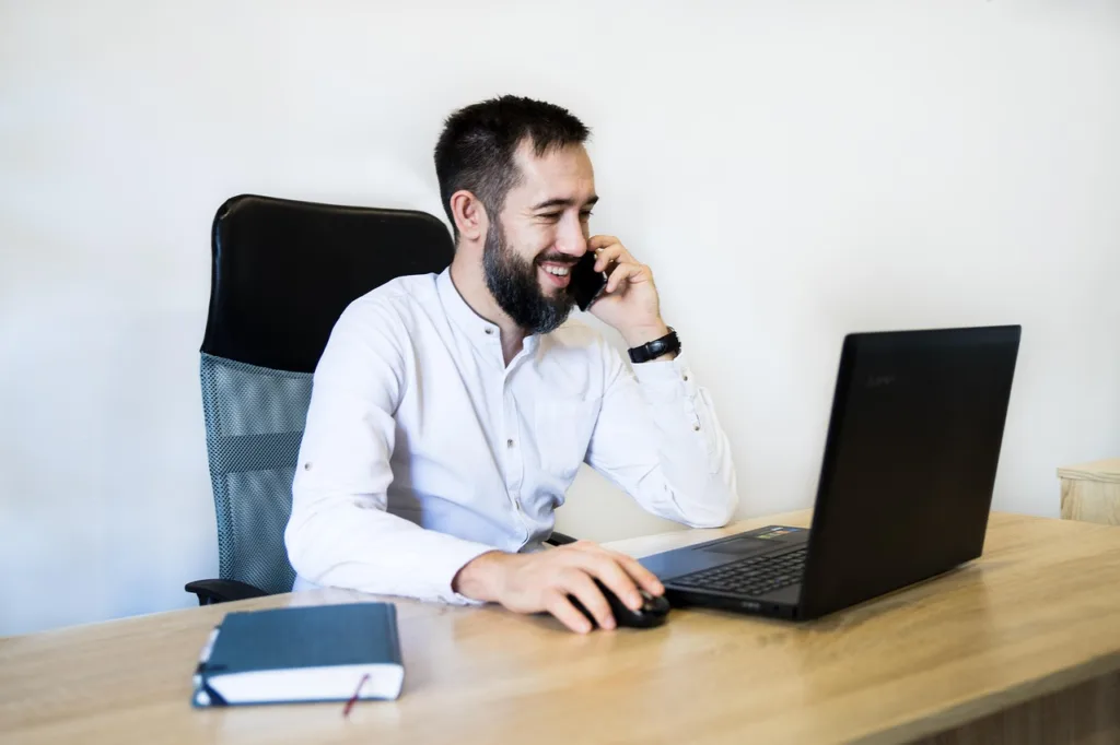 empresario sonriente usando tecnología para automatizar tareas y ganar tiempo en su PYME